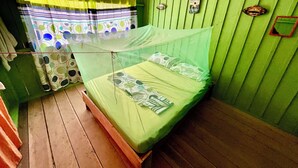 Huone, jossa on sänky, hyttysverkko ja verho.