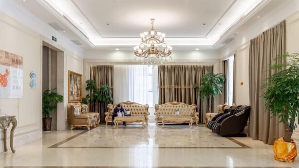 A spacious lobby with a chandelier, sofas, massage chairs, and potted plants. - Vienna International Hotel (Zhongxiang Zhongbai Square) (Zhongxiang)