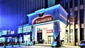 A hotel entrance with a prominent sign, large columns, and a modern facade. - Vienna International Hotel (Zhongxiang Zhongbai Square) (Zhongxiang)