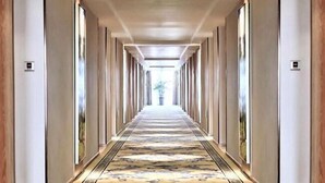 A long, narrow hallway with a patterned carpet, wooden paneling on the walls, and a ceiling with recessed lighting. - Vienna International Hotel (Zhongxiang Zhongbai Square) (Zhongxiang)