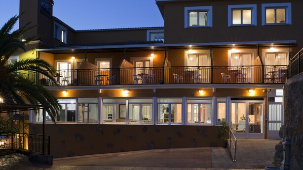 A hotel with a two-story structure, balconies, and a covered outdoor area.
