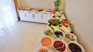 Ein reichhaltiges Buffet mit verschiedenen Speisen und einer Pflanze im Hintergrund.