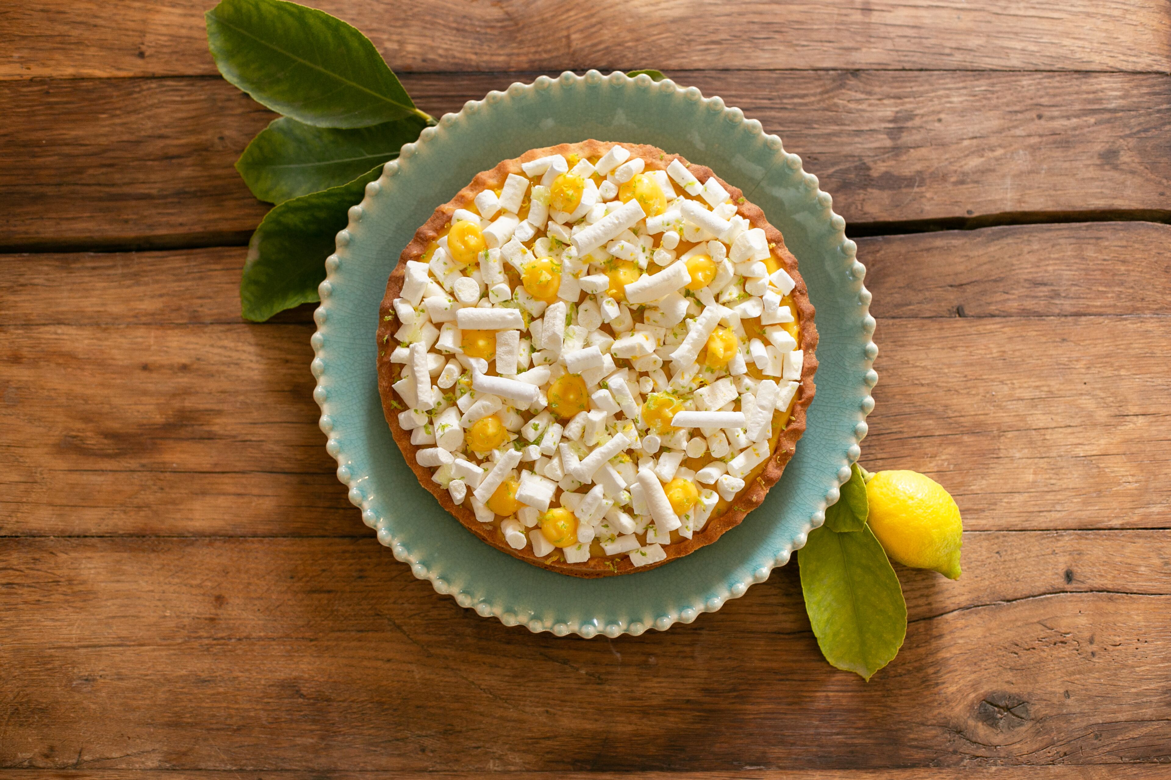 A round pastry on a teal plate with a wooden background.