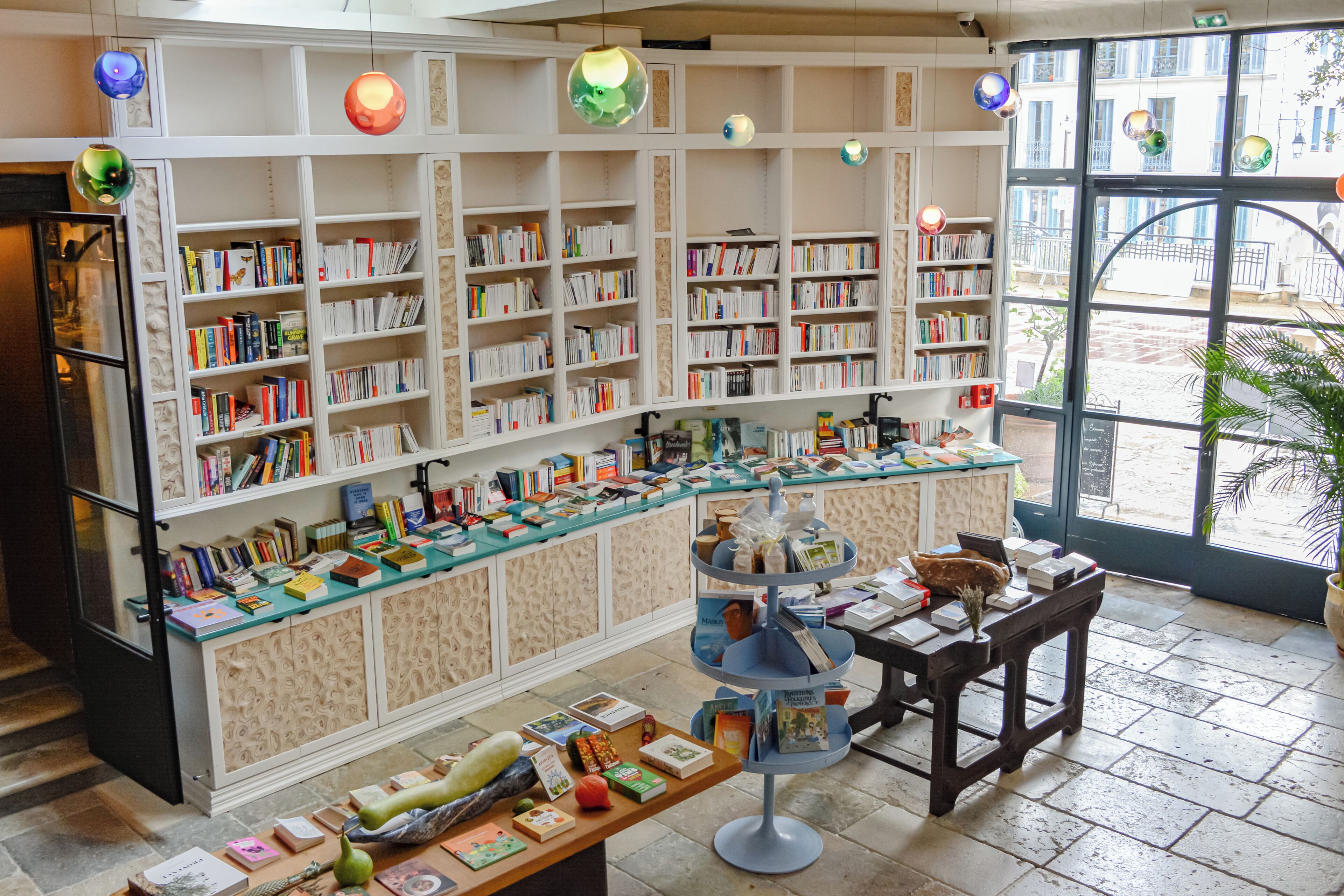 A bookstore with bookshelves, a checkout counter, and a display table with books and decorative items.