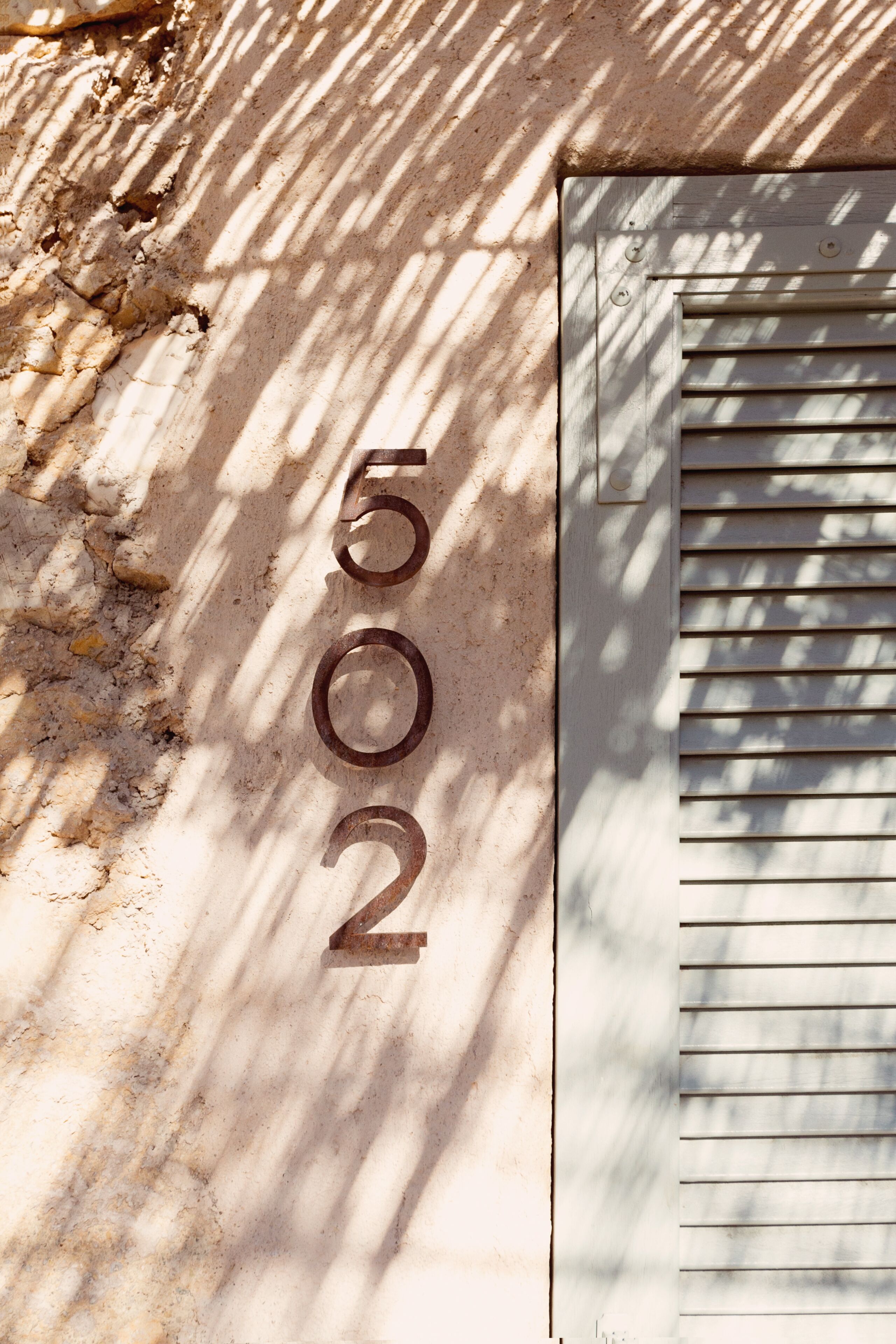 A building number '502' etched into a stone wall.