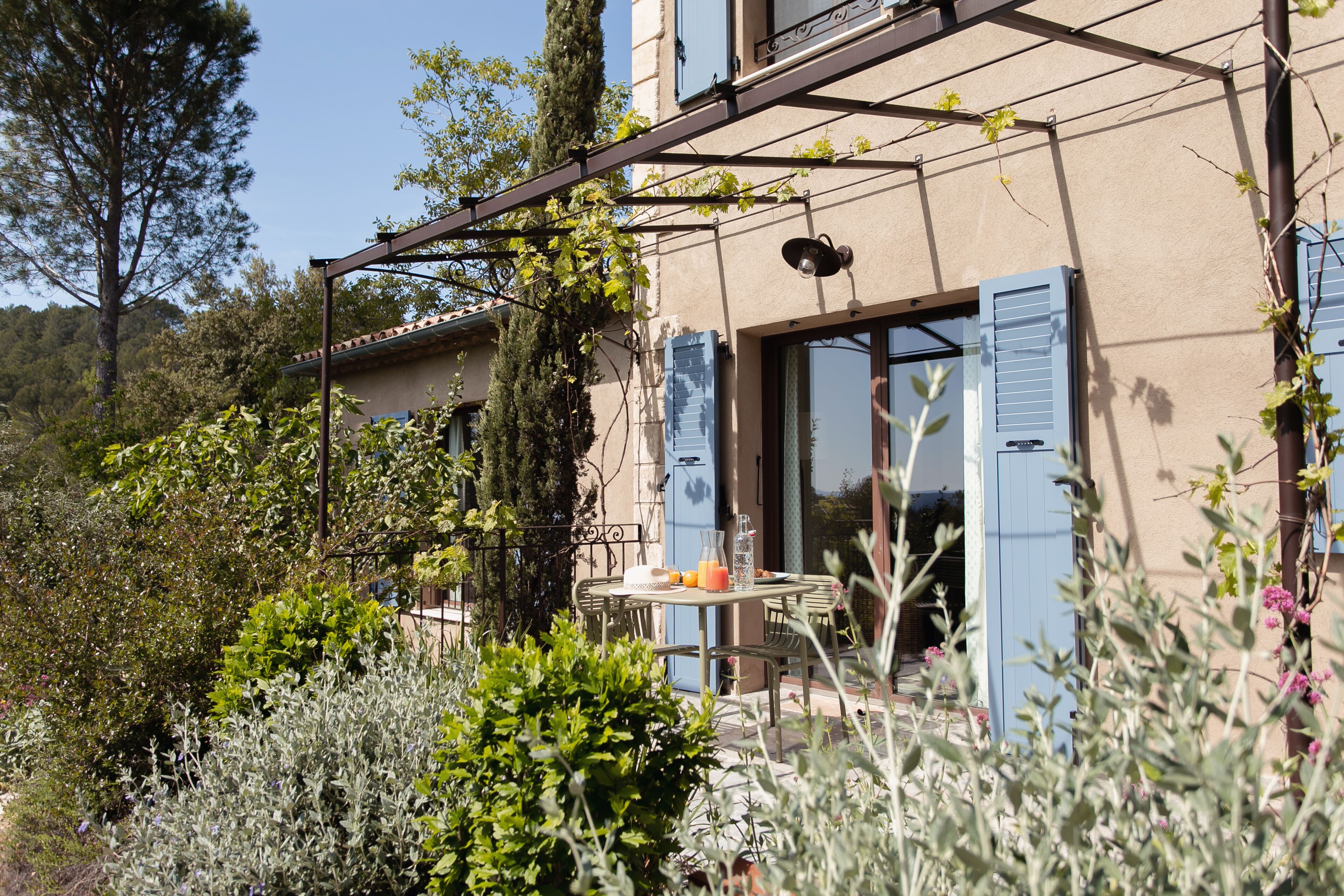 A house with a patio, a table with chairs, and a blue door.