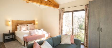 Une chambre à coucher comprenant un lit, des tables de chevet, un canapé et une armoire.