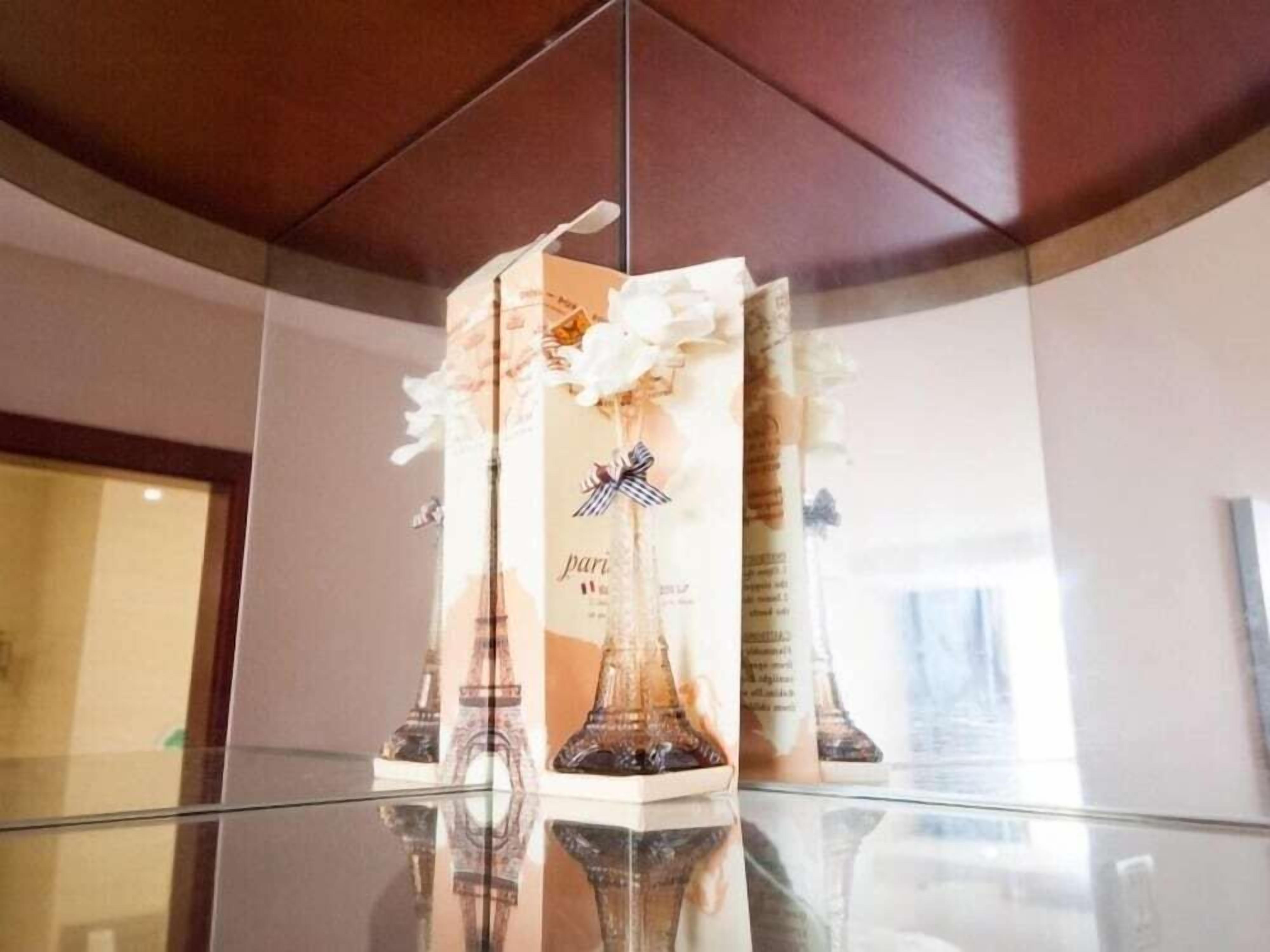 A glass display case with a Paris-themed perfume bottle.