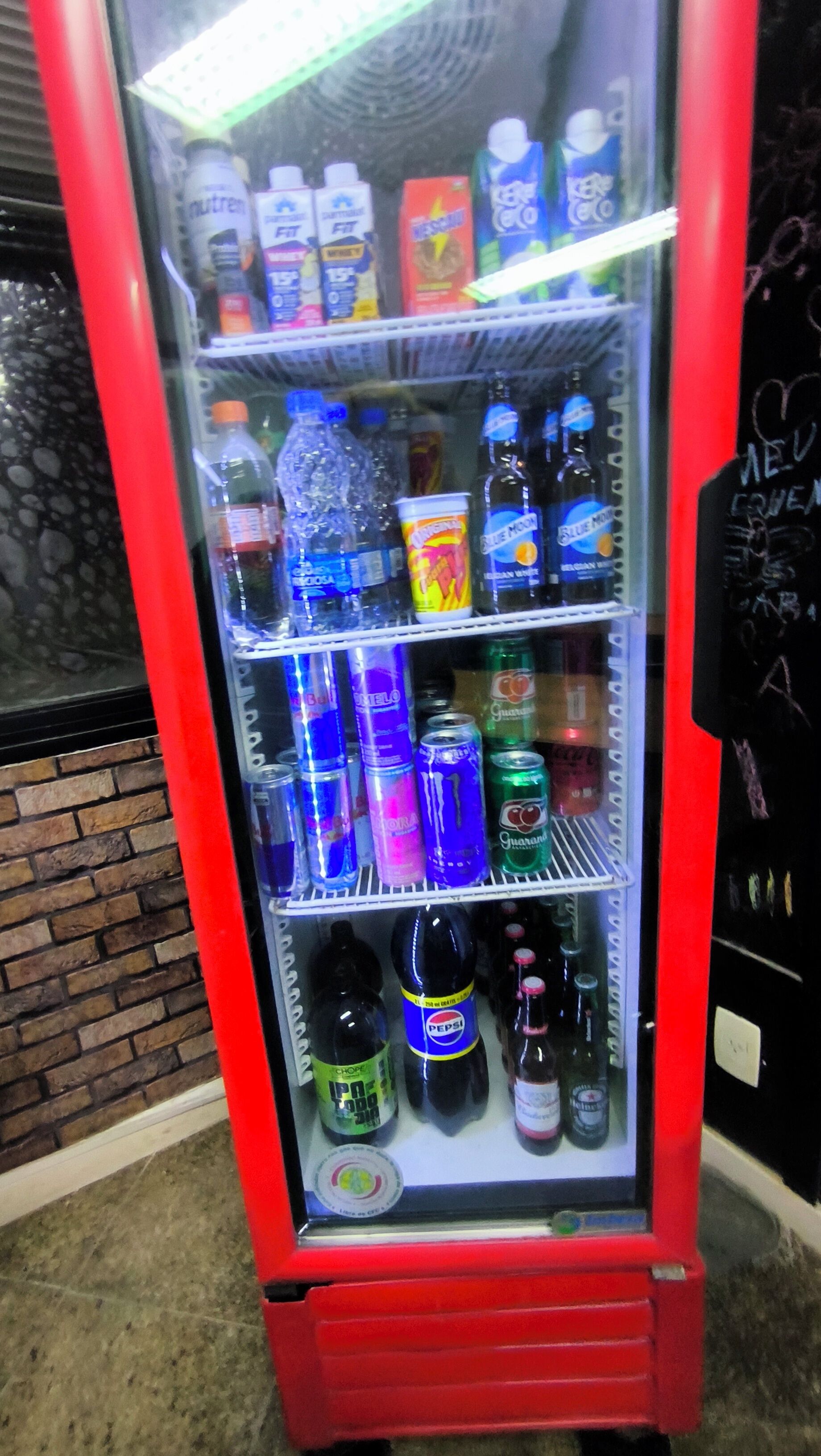 Máquina expendedora con diversas bebidas, como refrescos, bebidas energéticas y agua embotellada.