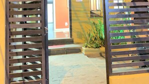 An entrance with metal gates, a visible door, and a sign indicating room number 22. - MEC Office Hostel (Niteroi)