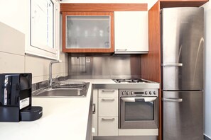 Departamento de diseñador, vista a la ciudad | Cocina privada | Refrigerador, microondas, horno y parrilla de estufa 