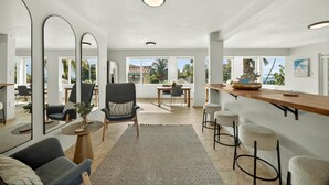 A modern living room with a dining area, large mirrors, and a view of the outdoors. - Palm Villa- Rooftop, Pool and Direct Beach Access (Río Grande)