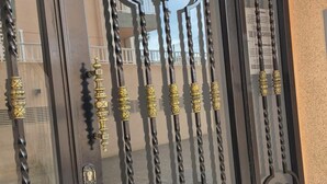 Een zwart metalen hekwerk met ingewikkelde decoraties en een messing sleutelgat.
