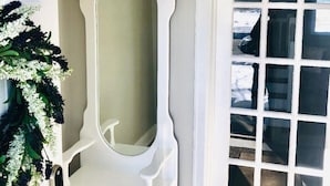 A white door with a mirror above it, a white wall, and a hanging light fixture. - ✽ Charming Cottage ✽ close to College/Town/Station (Wheaton)