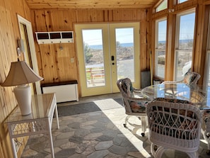 Relax in this serene room with a glass table, wicker chairs, and a comfortable bench.