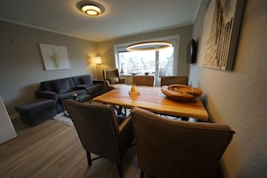 Relax in this stylish living room with a dining table, sofa, and side table, perfect for unwinding.