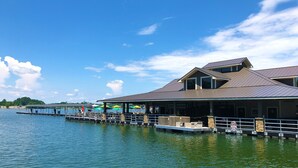 Ein Gebäude am Wasserufer mit einer überdachten Terrasse und einer anlegbaren Mole.