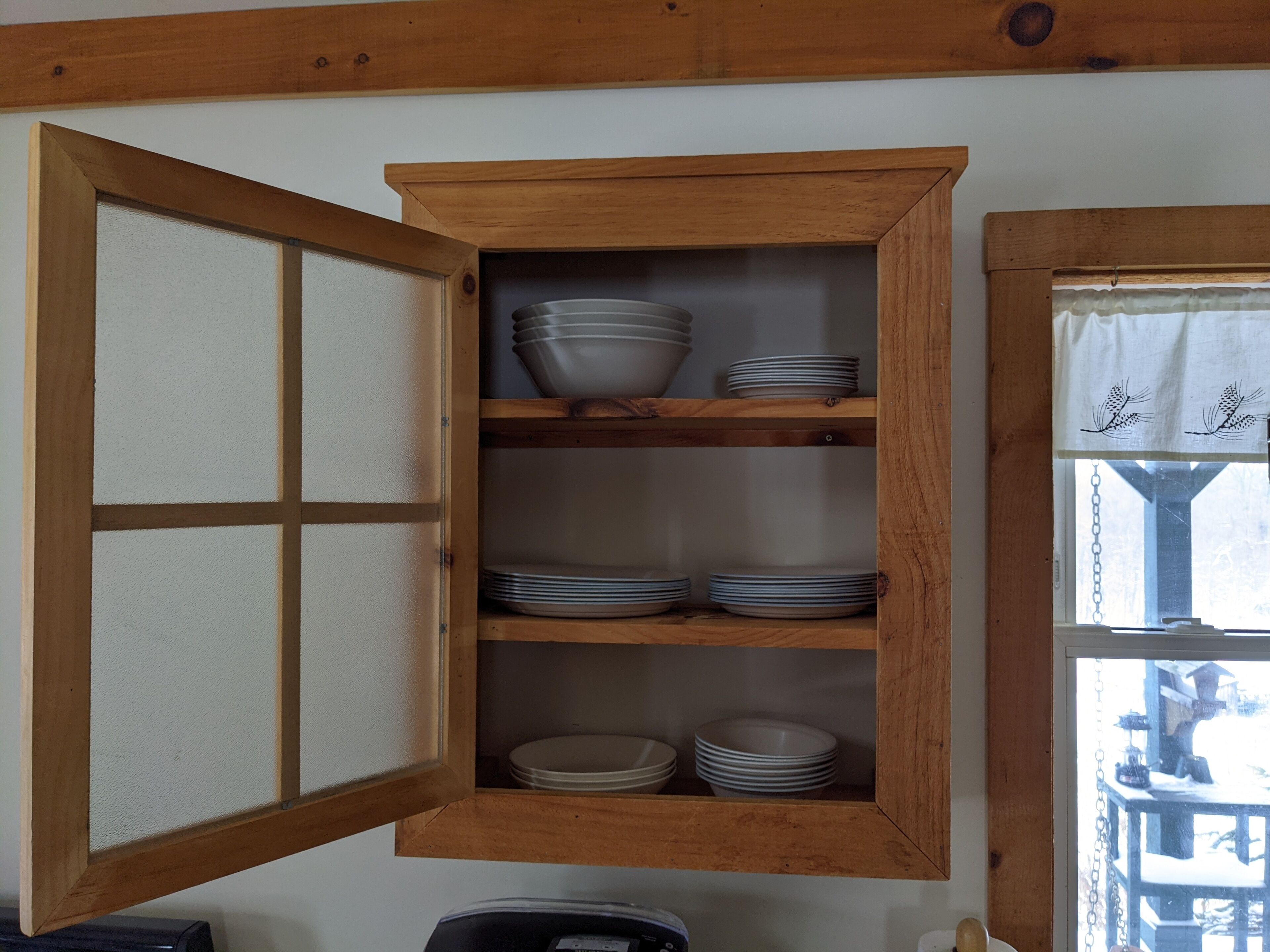 Un mueble de madera con varios estantes, algunos con platos apilados.