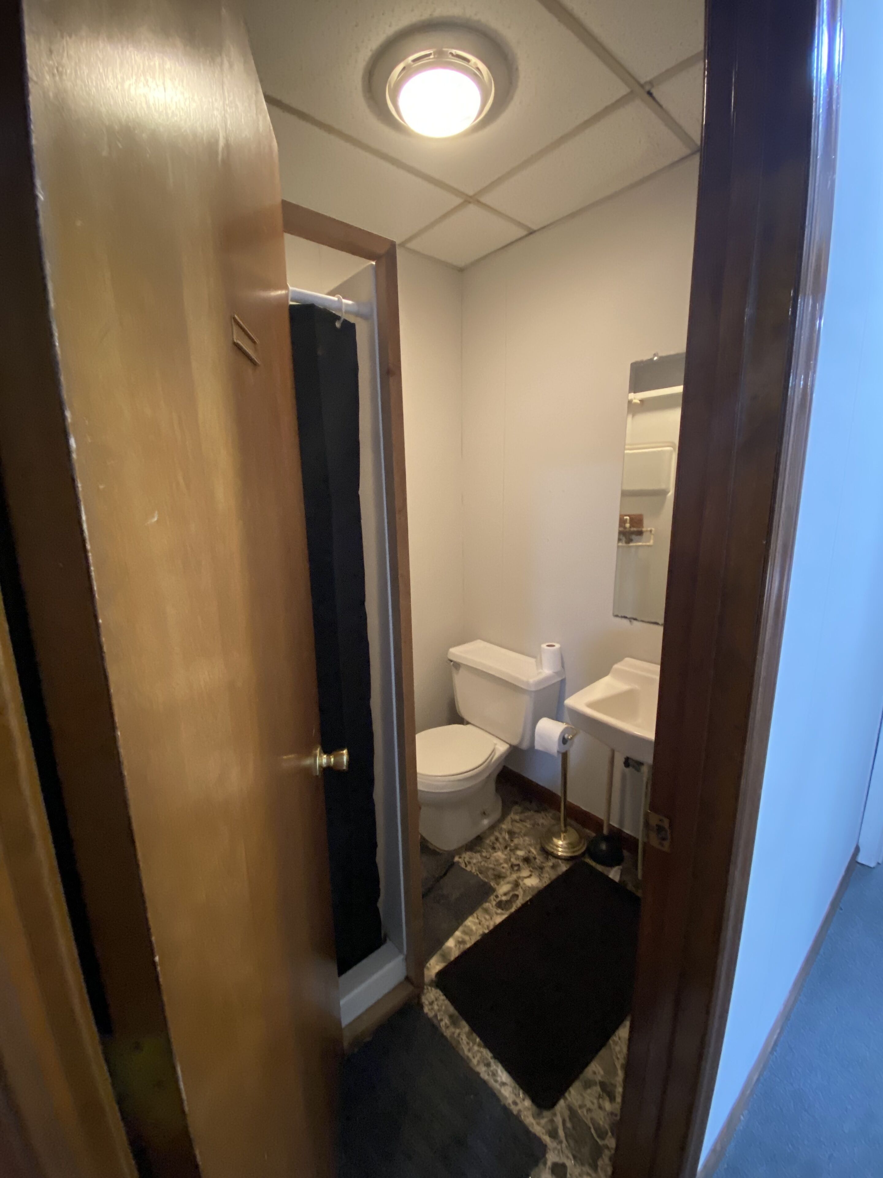 Une salle de bain comprenant des toilettes, un lavabo et un espace douche.