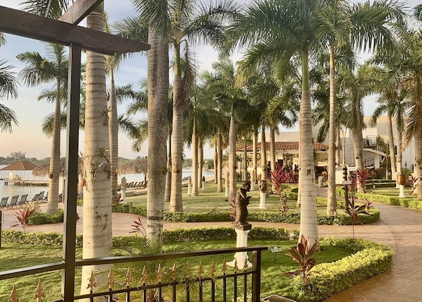 A resort with palm trees, a pool, and a statue.