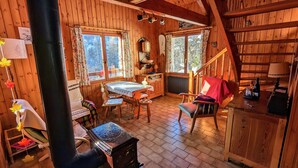 A cozy cabin interior with a dining area, a fireplace, and a kitchen. - Authentic chalet in the heart of Serre Chevalier, 300m from the slopes (Saint-Chaffrey)