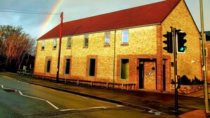 A two-story building with a red roof and stone facade, located at a street corner with a traffic light. - The Temple Inn (Bristol)