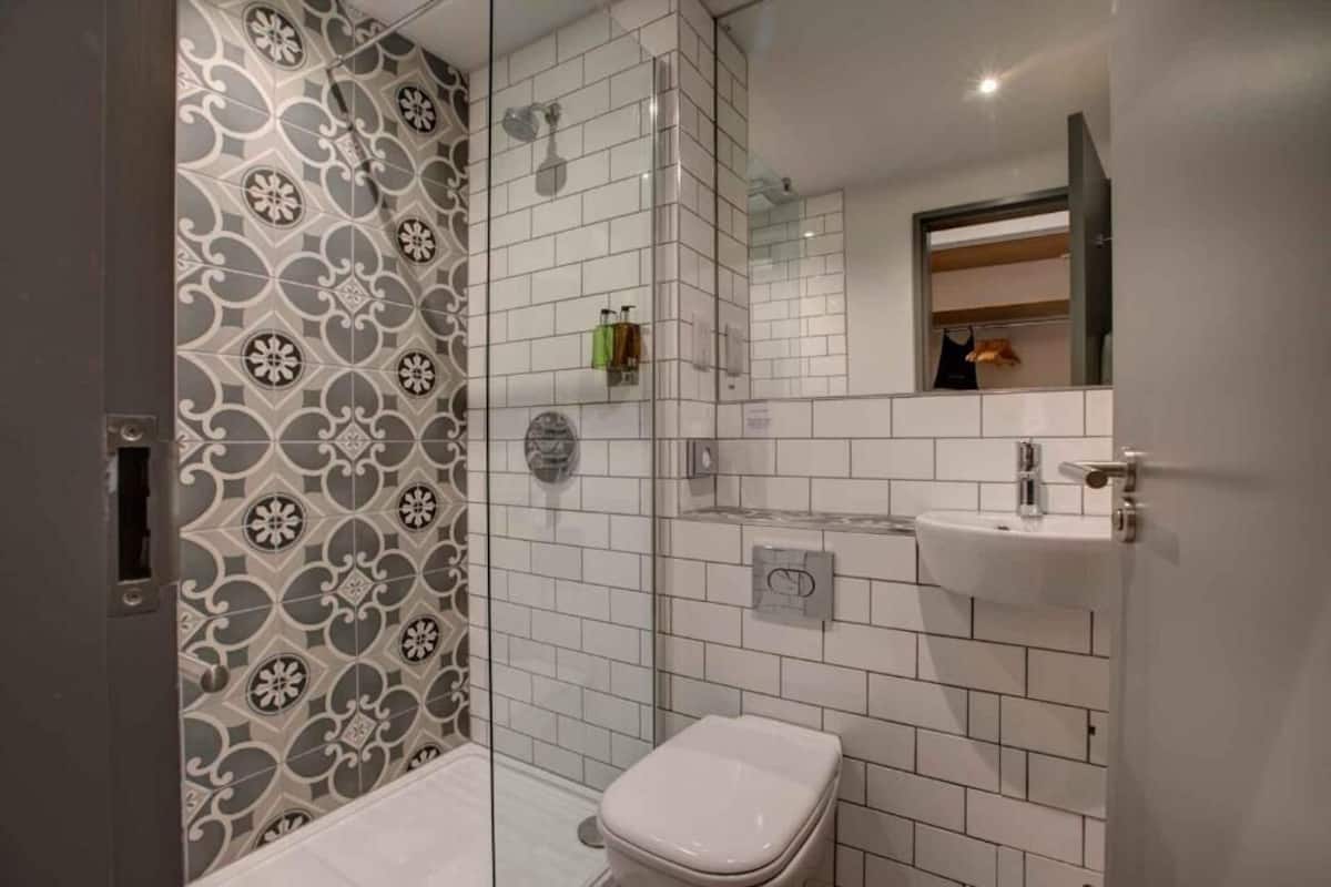 A bathroom with a shower, toilet, and sink.