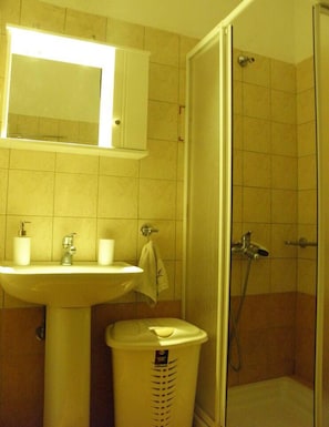 A bathroom with a sink, mirror, and shower. - Cozy and Modern Apartment Centrally Located (Volos)