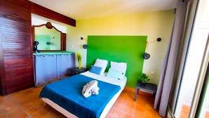 Ein Hotelzimmer mit Bett, Nachttisch, Spiegel und Fenster.