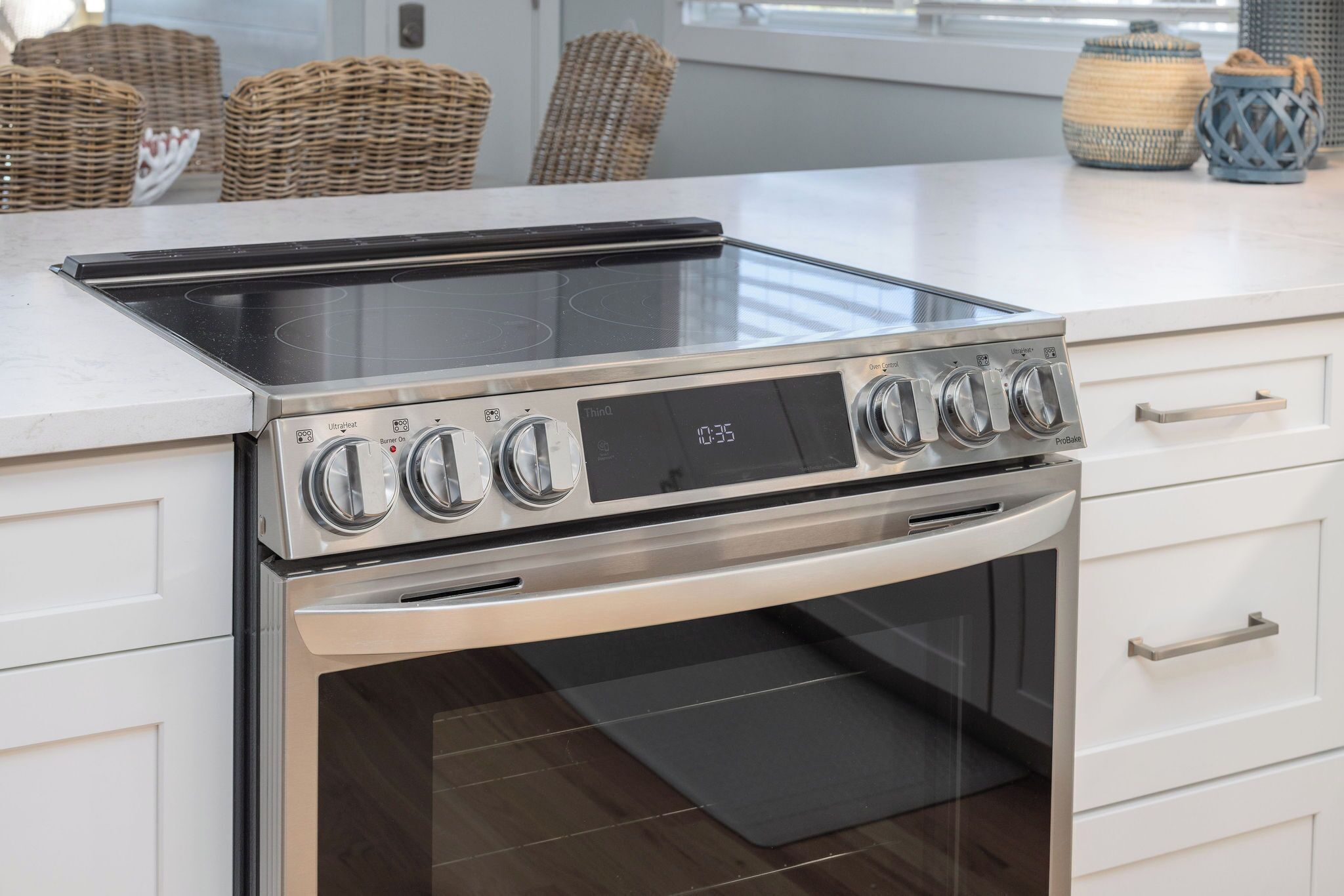 A kitchen with a built-in stove, oven, and a white countertop.
