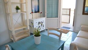 A room with a table, chairs, a white cabinet, a mirror, and a potted plant. - Accommodation Mediterraneo Verde - Marzamemi (Marzamemi)