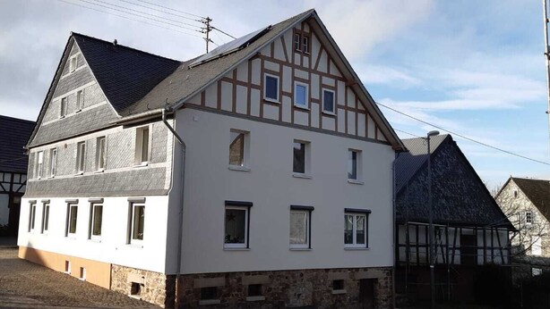 A traditional half-timbered house with a steep gabled roof, multiple windows, and a stone foundation. - Vacation apartment in the Moselle valley, near the Middle Moselle (Raversbeuren)