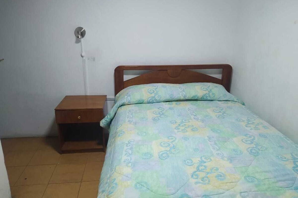 Habitación doble | Edredón, muebles diferentes y escritorio