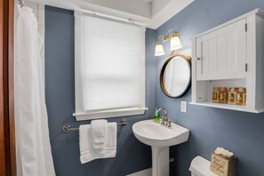 A bathroom with a white sink, a mirror, and a towel rack. - Joppa Flat (Newburyport)
