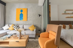 Relax in this stylish living space with a sofa, armchair, and comfortable bed.