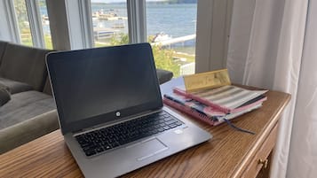 Um laptop sobre uma mesa de madeira com um caderno e uma placa que diz 'Everyday I'm Hustlin'.