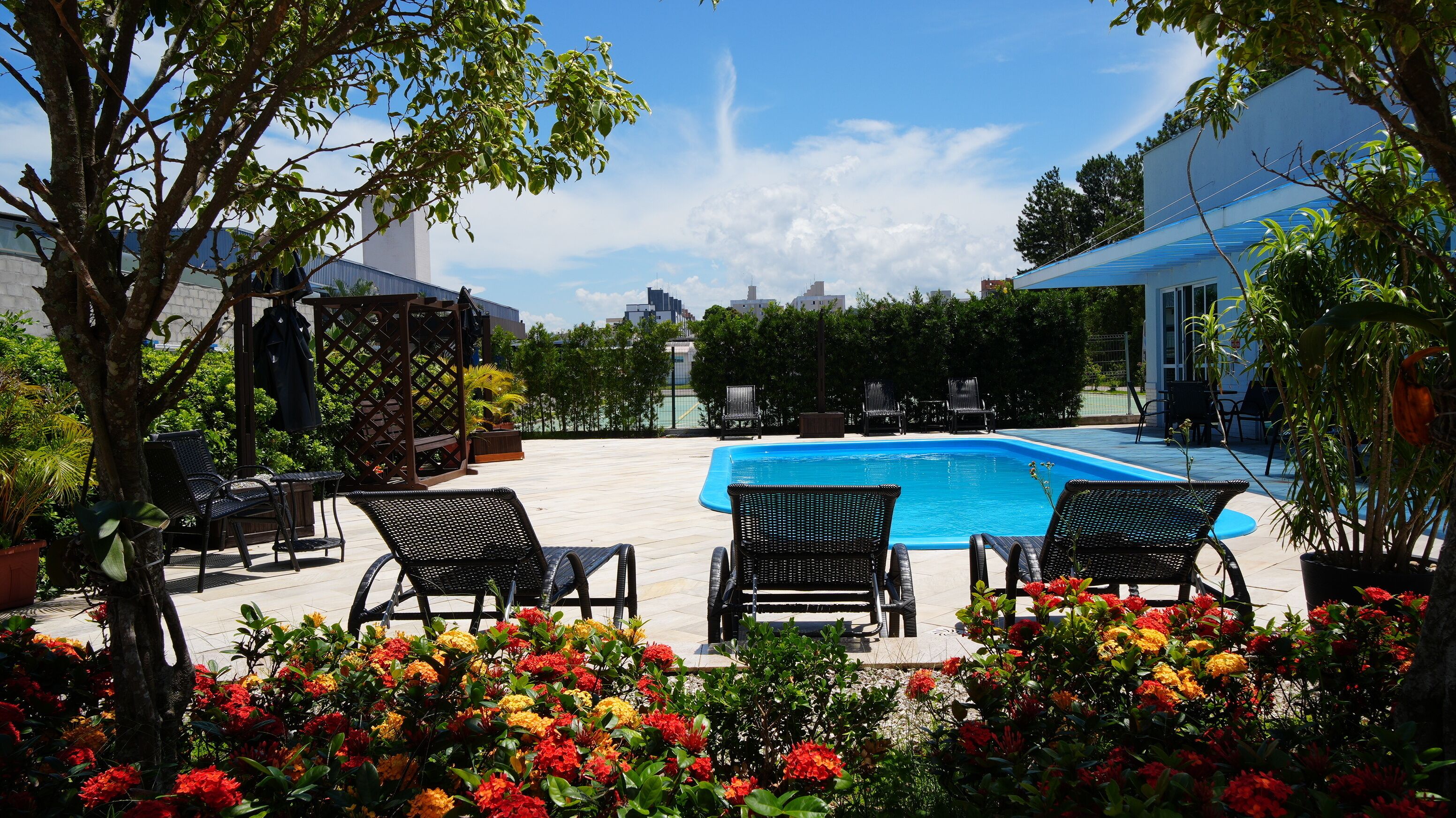 A swimming pool with lounge chairs and potted plants.