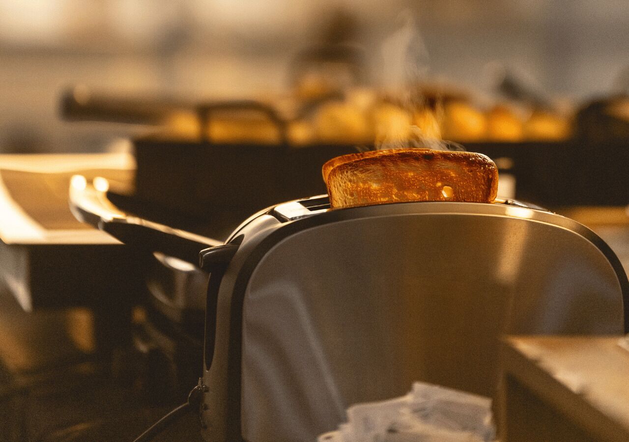 A close-up of a portable cooking device with a lid, possibly a portable stove or grill, with a focus on the lid's texture and the device's metallic frame.