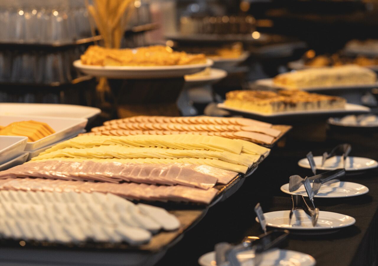 A buffet with various food items and plates.