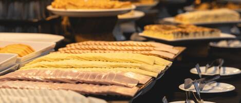 A buffet with various food items and plates.