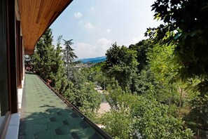 A balcony with a view of a lush green landscape and distant mountains. - Can Termal & Kaplica Apart Hotel (Termal)