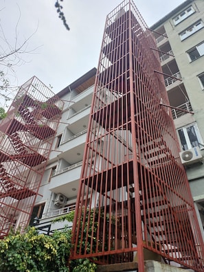 A multi-story building with a red metal staircase and balconies. - Can Termal & Kaplica Apart Hotel (Termal)