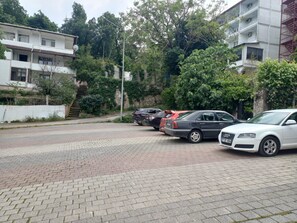 A parking area with several cars, a staircase leading to a building, and a tree-lined background. - Can Termal & Kaplica Apart Hotel (Termal)