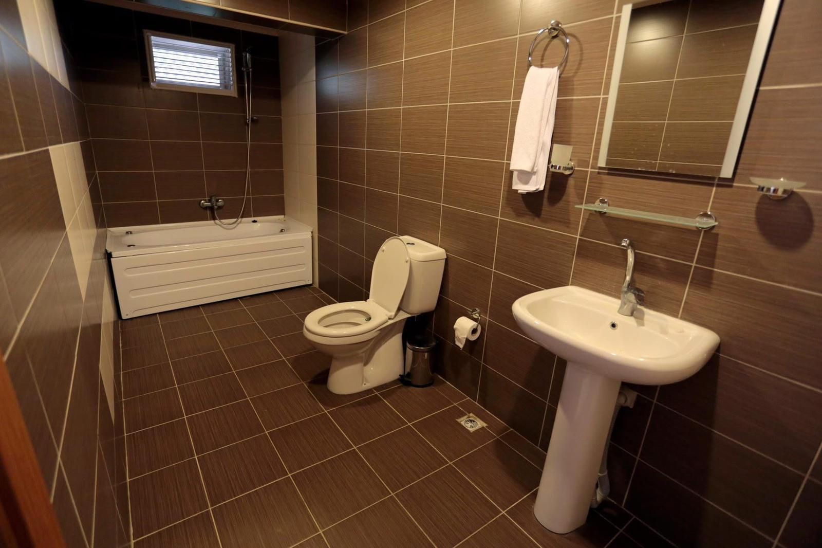 A bathroom with a toilet, sink, and bathtub.