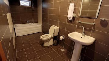 A bathroom with a toilet, sink, and bathtub.