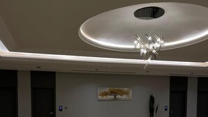 A spacious, modern lobby with a high ceiling, a central chandelier, and a minimalist design. - Voyage Serviced Apartments فوياج للشقق المخدومة (Riyadh)