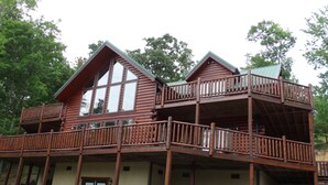 A wooden cabin with a balcony and a porch. - KNOTTYWOOD - Upscale, Elegant, 8X Award-Winning! - Located in pvt. gated resort. (Gatlinburg)