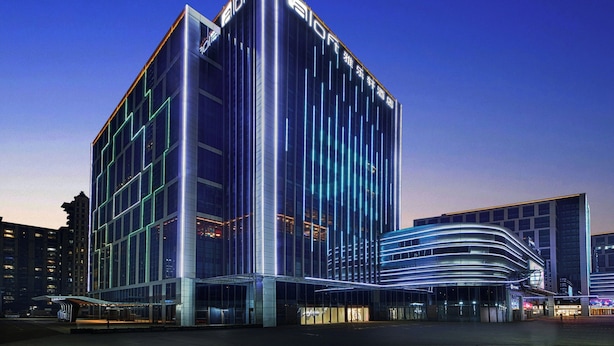 A modern hotel with a prominent 'Aloft' sign, featuring a glass facade and a curved entrance. - Aloft Shijiazhuang (Shijiazhuang)