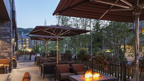 Ein Terrassenbereich im Freien mit Sitzgelegenheiten und einem Feuerplatz.