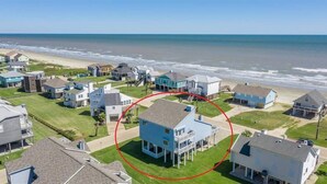 Zona residencial costera con casas, algunas con balcones, y una playa al fondo.